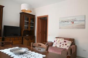 a living room with a dining room table and a television at Bilocale con balcone a Numana - N080 in Sirolo