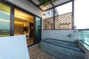 un baño con bañera y ducha de cristal en 嬉安平 Si Anping by Hotel Si, en Tainan