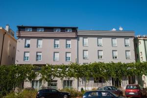 a large building with cars parked in front of it at Hotel Glorija in Međugorje