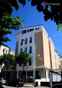 a building with a sign on the front of it at Senator Hotel in Tirana