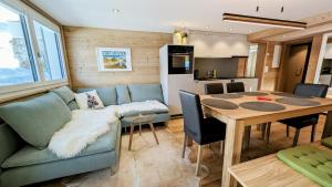 a living room and dining room with a couch and a table at Imhof Alpine B&B Apartments in Bettmeralp