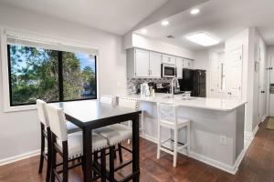 Una cocina con gabinetes blancos y una mesa y sillas. en Cypress Bay EE15, en Little River