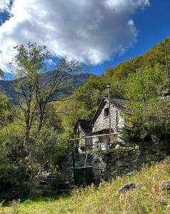 an old stone house in the middle of a field at Rustic on the Verzasca River in Corippo