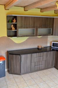 ヤブルニツァにあるСадиба "Альпійській дворик"のキッチン(木製キャビネット、黒いカウンタートップ付)