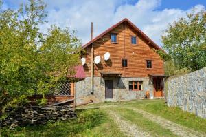 a large wooden barn with a stone wall at Садиба "Альпійській дворик" in Yablunytsya