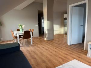 Una sala de estar con mesa y sillas y un comedor. en Hvammur Apartments by the Harbour, en Höfn