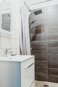 Un baño con ducha y lavabo blanco. en À 2 Pas de la Plage Cosy et Super Équipé, en Le Havre