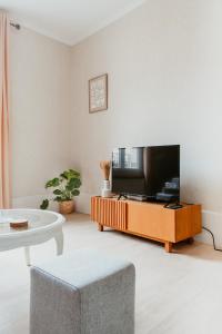 Una sala de estar con un televisor y una mesa. en À 2 Pas de la Plage Cosy et Super Équipé, en Le Havre