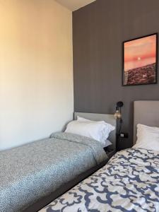 a bedroom with two beds and a picture on the wall at Bilocale luminoso ed elegante-Parcheggio gratuito in La Spezia