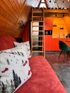 a bedroom with a bed and a ladder in a room at A-frame-hub з форелевою риболовлею in Slavske