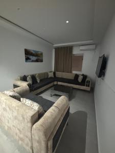 a living room with two couches and a television at Résidence Maha in Hammam Sousse