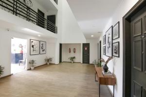 a hallway with white walls and a large room with a table at FabHotel Infinity Stays Near Medanta- The Medicity, Gurgaon in Gurgaon