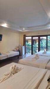 a bedroom with two beds and a large window at ปราณบุรีน้อยรีสอร์ท in Ban Nong Sua