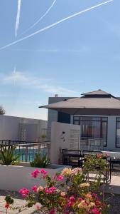 un patio con flores y mesas y un edificio en concrete villa, en Badīyah