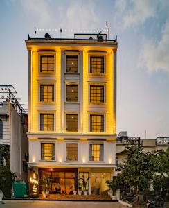 MAYA'S MANOR - A Luxury Lake View Boutique Hotel في أودايبور: مبنى أصفر طويل مع الكثير من النوافذ