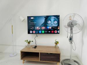 Camera con TV e scrivania con ventilatore. di 2BR Near Clark - Fast Wifi - Self Check-in a Mabalacat