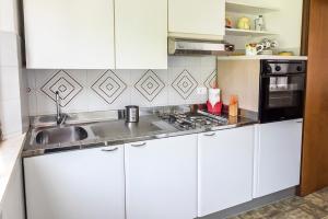a white kitchen with a sink and a microwave at A28 - Poggio, trilocale vista mare in Ancona