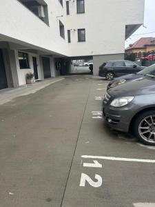 a parking lot with cars parked in front of a building at C&E Apart in Craiova +7 photos