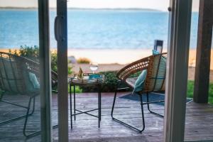a patio with two chairs and a table with a wine glass at Beach 106 Direct Access Near Downtown Tart Trail in Traverse City +25 photos