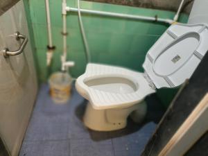 Parvati Niwas Homestay -5 Mins walking frm Revdanda Beach & Fort -Free Wifi في آليباغ: حمام مع مرحاض أبيض في المقصورة