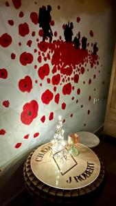 a table with red flowers on a wall at In De Wulf in Ieper