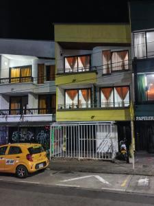 a yellow car parked in front of a building at colibrí Hostel in Armenia