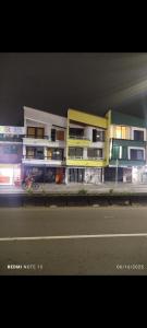 a building on the side of a street at night at colibrí Hostel in Armenia