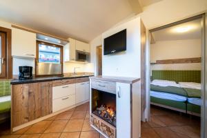 a kitchen with a fireplace in a room at Chalets Camping Brunner am See in Döbriach