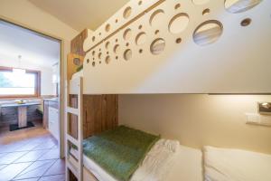a bedroom with a bunk bed and a bathroom at Chalets Camping Brunner am See in Döbriach +18 photos