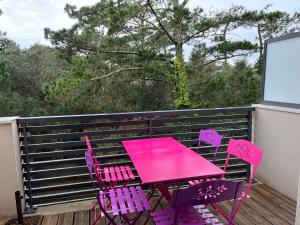 een roze tafel en stoelen op een balkon bij Labenne Océan in Labenne +12 foto's