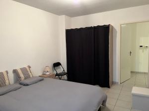 een slaapkamer met een bed en een zwart gordijn bij Labenne Océan in Labenne