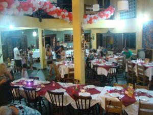 a group of people sitting at tables in a restaurant at Pousada Y-Goá in Bertioga