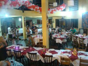 a group of people sitting at tables in a restaurant at Pousada Y-Goá in Bertioga +37 photos