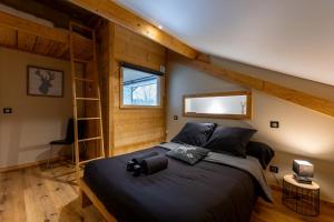 Un dormitorio con una cama grande en una habitación. en La Fromagerie - Gîte d'exception à La Mouille, en La Mouille