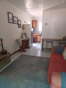 a living room with a red couch and a kitchen at The Roaches in White River