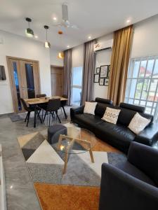 a living room with a black couch and a table at La Villa K - 1 Chambre Salon in Lomé