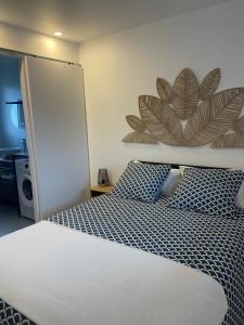 a bedroom with a white bed with blue pillows at Maisonnette cosy proche de la côte in Lesneven