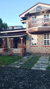 a brick house with a balcony and a patio at Villa Kota Bunga Q4-17 in Cikundul +2 photos