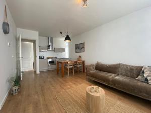 a living room with a couch and a table at NEW Appartment Zandvoort! in Zandvoort