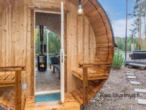 an outside view of a wooden building with an open door at Villa Renkaranta - Modern villa for 8-12 person, own beach, sauna & hot tub - surrounded by forests in Hämeenlinna