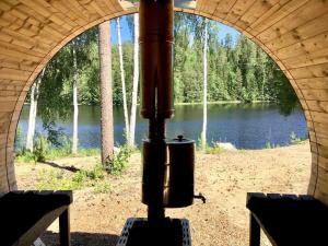 a view of a lake from an archway with a stove at Villa Renkaranta - Modern villa for 8-12 person, own beach, sauna & hot tub - surrounded by forests in Hämeenlinna