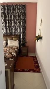 Résidence Maamoura rabat في Oulad Yakoub: غرفة صغيرة بسرير وستارة