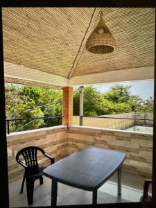 een tafel en een stoel op een afgeschermde veranda bij Tekrour- La case des hotes -Chambre lumineuse proche plage in Mbour