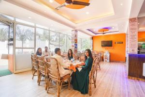 a group of people sitting at a table in a restaurant at Via Shanel Beachside Resort - Tito's lane, Baga Beach in Baga