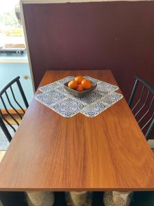 een houten tafel met een kom sinaasappels erop bij The Desert Farm in Escalante