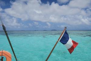 una bandera en la parte trasera de un barco en el agua en Zaru Hotel, en Gizo
