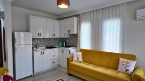 ein Wohnzimmer mit einer gelben Couch in einer Küche in der Unterkunft İnlice Apart in Fethiye