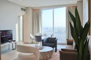 a living room with a table and chairs and a large window at Casa Royale Vacation Home - Dubai Marina in Dubai