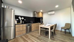 eine Küche mit Tisch und Edelstahlkühlschrank in der Unterkunft Casa da Moura - Arcos de Valdevez in Arcos de Valdevez
