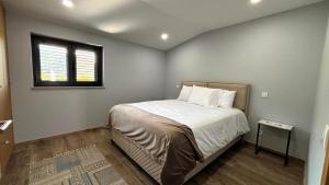 ein kleines Schlafzimmer mit einem Bett mit Fenster in der Unterkunft Casa da Moura - Arcos de Valdevez in Arcos de Valdevez